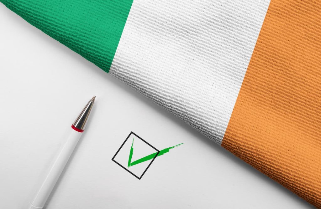 A Comprehensive Guide to the New Form VIF in Ireland 3 Irish flag next to pen and completed checkbox, symbolizing the completion and approval of the new VIF form process in Ireland.
