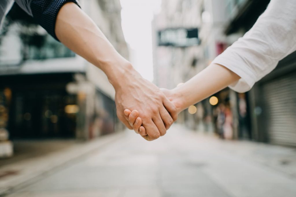 Everything You Need to Know About Civil Partnership Certificates 2 Close-up of a couple holding hands on a city street – symbolizing civil partnership. Learn how to notarize or Apostille your civil partnership certificate with NotaryPublic24.