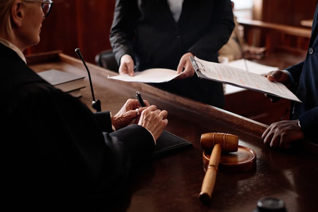 The Essential Guide to Court Documents: Notarization and Apostille Explained 9 Close-up of a judge and legal professionals handling official court documents. Learn how to notarize and Apostille court papers with NotaryPublic24.