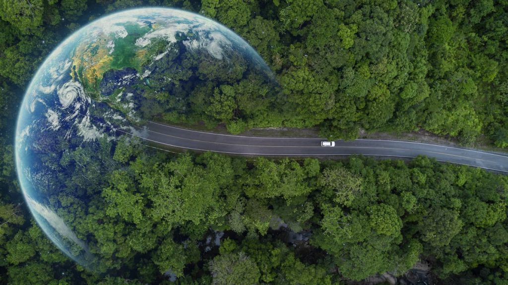 Everything You Need to Know About International Driving Licenses: A Comprehensive Guide 4 A car driving through a forest with a superimposed Earth – symbolizing international travel freedom. Learn everything about International Driving Licenses and how to get yours verified with NotaryPublic24.