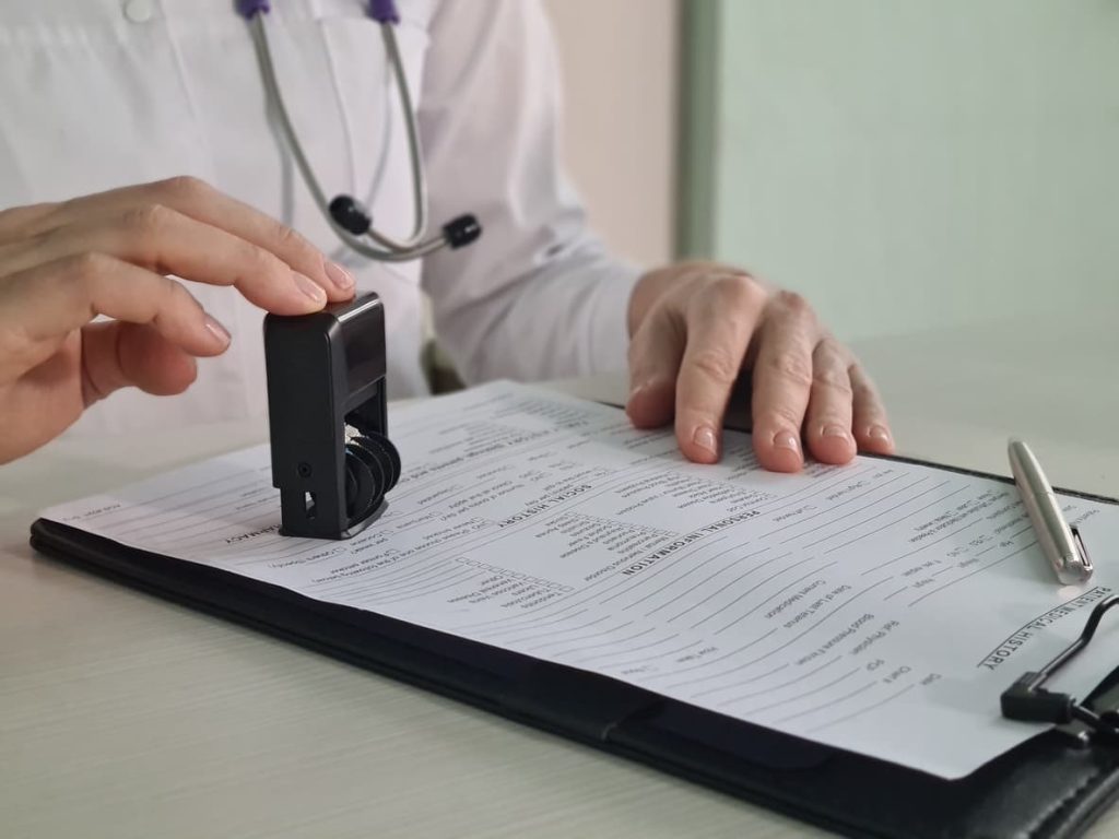 The Medical Report: Your Essential Guide for International Use and Immigration 5 Doctor stamping a medical report – essential for immigration, visa applications, and international use. Learn how to get your medical report notarized with NotaryPublic24.